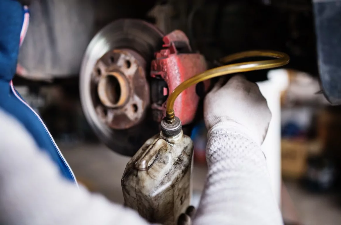 mechanic changing brake fluid